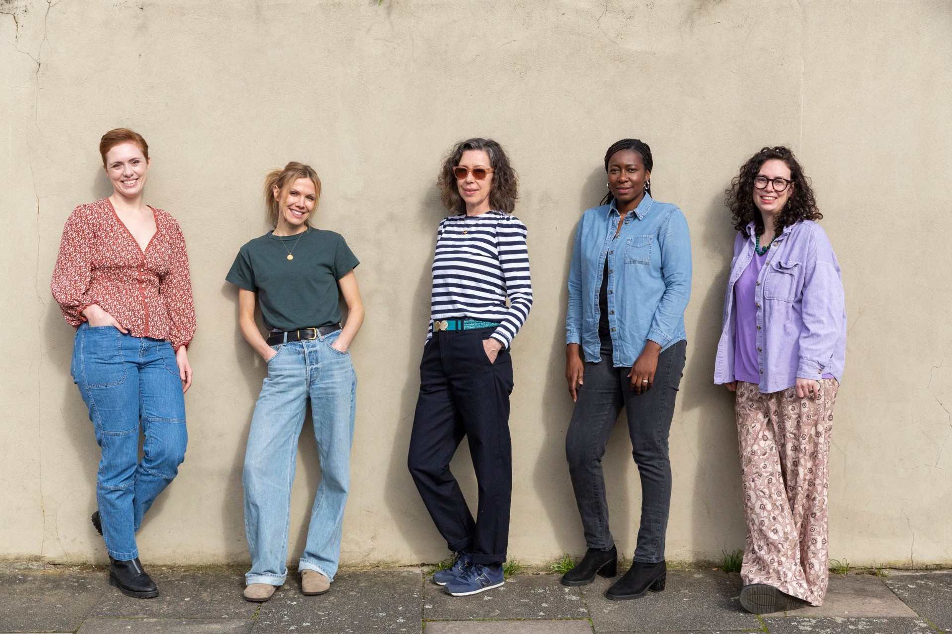 Five doulas from The Doula Club network standing together against a wall